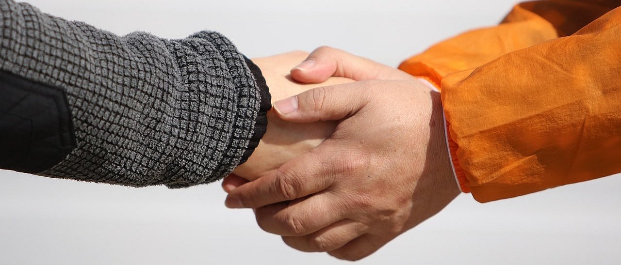 zwei Personen geben sich die Hand